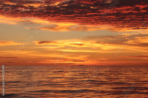 Sunset. Dramatic sunset sky with clouds. Dramatic sunset over the sea © Dimsplash