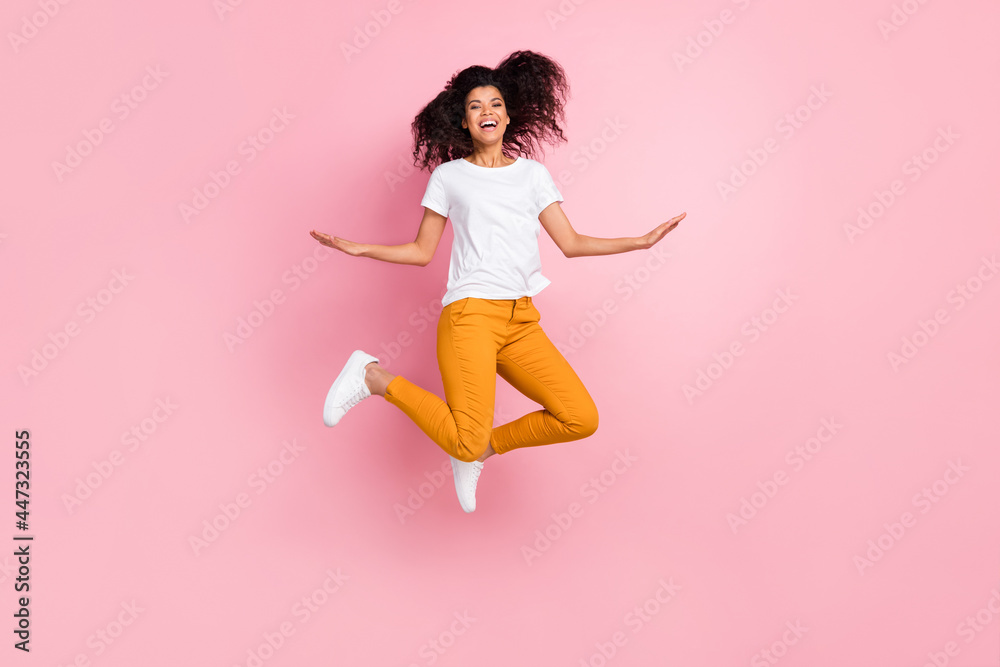 Full body photo of cool wavy hairdo young lady jump wear t-shirt trousers isolated on pink color background