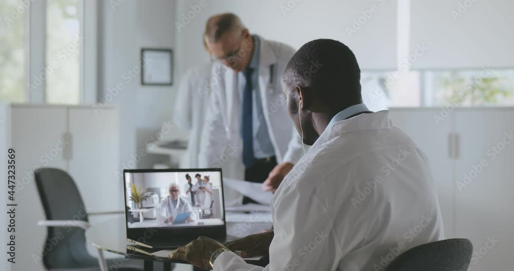 Afro-american male practitioner consulting colleague online on video call