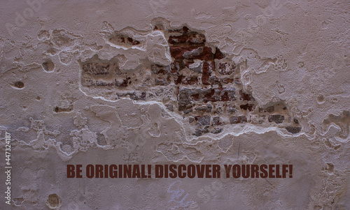 A text message on the background of the ruined plaster wall: BE ORIGINAL! DISCOVER YOURSELF! Concept of being yourself. Concept of mental work. Used wall of a Venetian house. photo