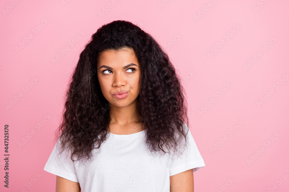Photo of doubtful pretty dark skin woman dressed white t-shirt looking empty space isolated pink color background Photo of doubtful pretty dark skin woman dressed white t-shirt looking empty space isolated pink color background