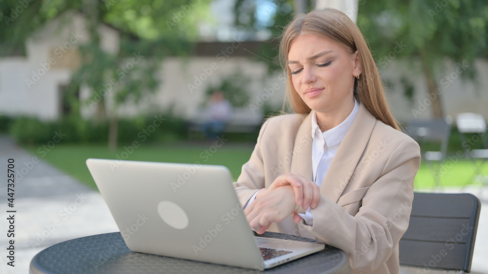 Businesswoman with Laptop having Wrist Pain in Outdoor Cafe Businesswoman with Laptop having Wrist Pain in Outdoor Cafe