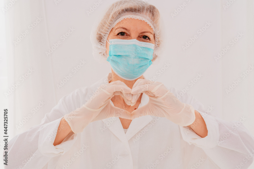 Doctor with mask makes a heart with her hands Doctor with mask makes a heart with her hands