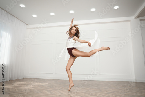 Beautiful professional dancer practicing moves in studio