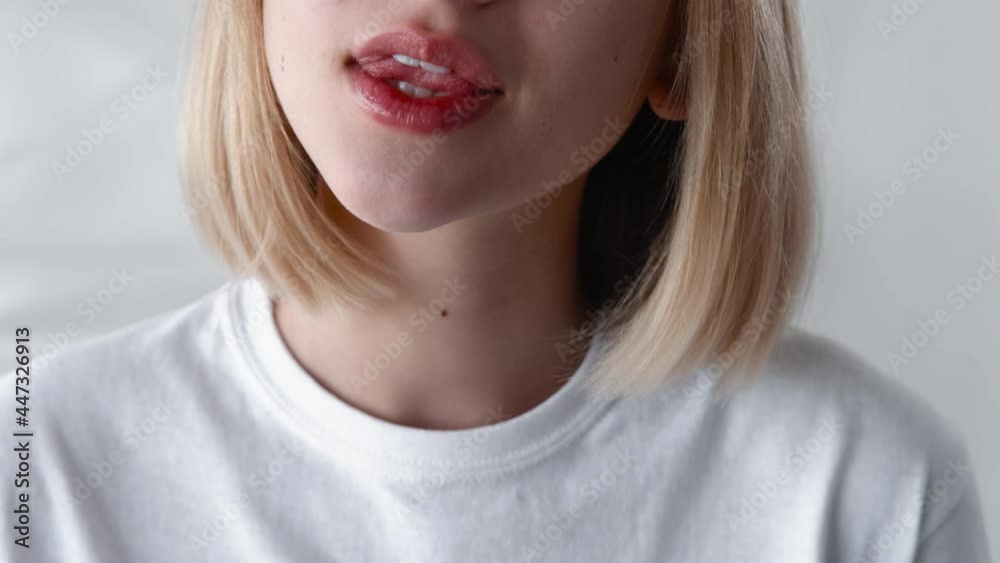 Lip care. Moisturizing hygiene. Beauty skincare. Teen makeup. Cosmetic product. Unrecognizable relaxed smiling girl applying shiny balm isolated on light.
