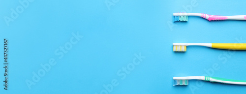 Toothbrushes on light blue background, flat lay. Space for text