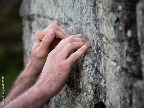 A climber's hands on rock in Kingussie, Scotland