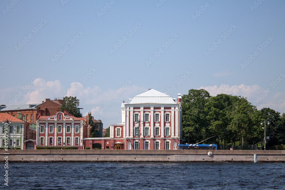 the historic building of the twelve colleges in the classical style on the University embankment near the Neva River on a sunny summer day in Saint-Petersburg