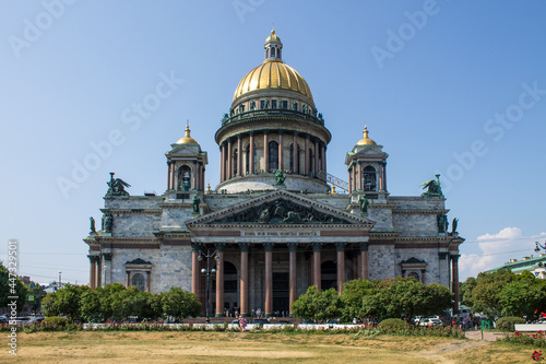 the beautiful facade of St. Isaac's Cathedral with a golden dome and monumental columns on a clear sunny summer day in Saint-Petersburg Russia