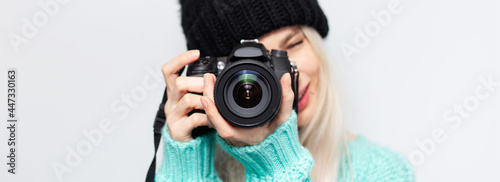 Panoramic portrait of pretty girl taking photo on DSLR camera, on white.