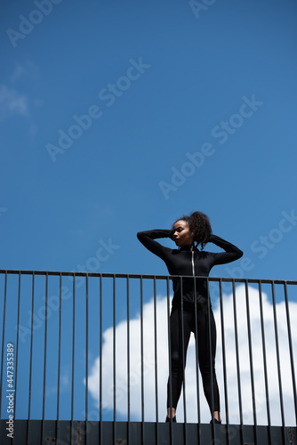 Low angle view of african american sportswoman standing on bridge