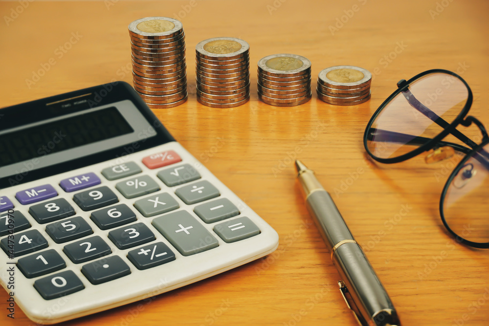 busines, finance, money and bookkeeping concept - calculator, eyeglasses and thai coins on office table. busines, finance, money and bookkeeping concept - calculator, eyeglasses and thai coins on office table.