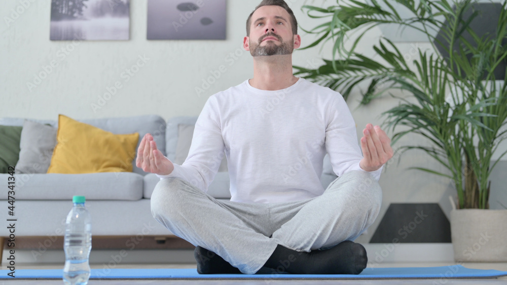 Fototapeta premium Close up of Peaceful Mature Adult Man Meditating on Yoga Mat at Home