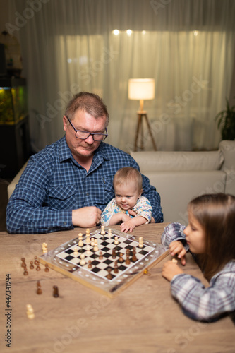 dad teaches his daughter to play chess