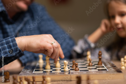 dad teaches his daughter to play chess