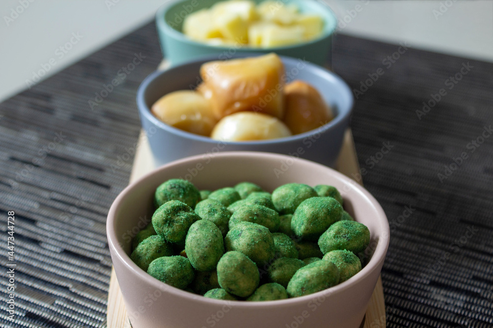 Snacks in colorful bowls on wooden board. Peanuts and cheese. Selective focus. Snacks in colorful bowls on wooden board. Peanuts and cheese. Selective focus.