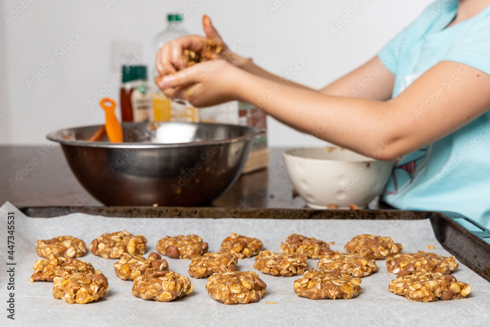 Liittle girl hands preparing oatmeal chocolate chips cookies
