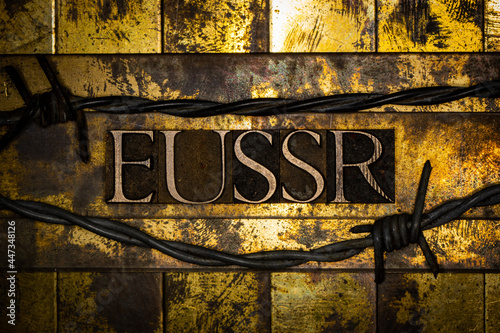 EUSSR text between barbed wire on vintage textured grunge gold and copper background photo
