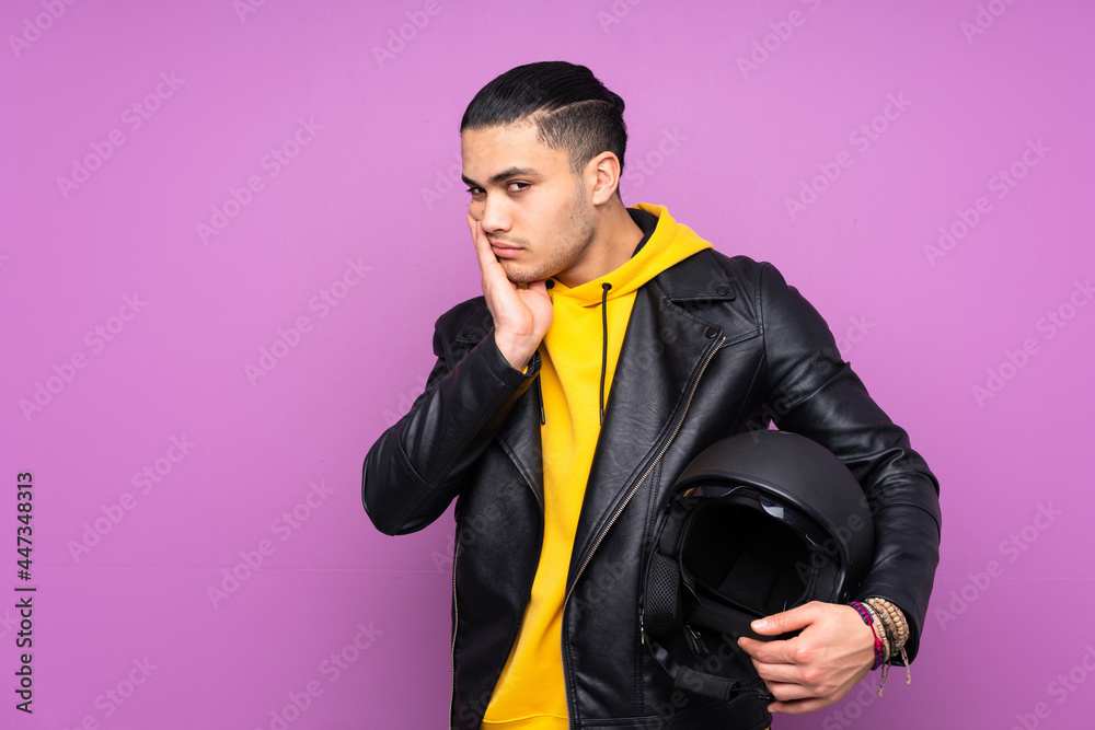 Man with a motorcycle helmet isolated on purple background unhappy and frustrated Man with a motorcycle helmet isolated on purple background unhappy and frustrated