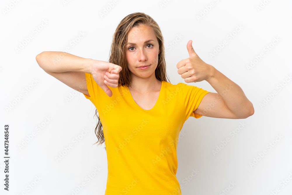 Young caucasian woman isolated on white background making good-bad sign. Undecided between yes or not Young caucasian woman isolated on white background making good-bad sign. Undecided between yes or not