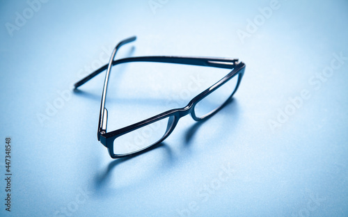 Black eyeglasses on the blue background.