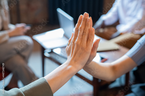 Two businesswomen making high-five gesture in working environment