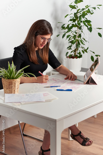 Illustrator woman draws sketches sitting at her desk