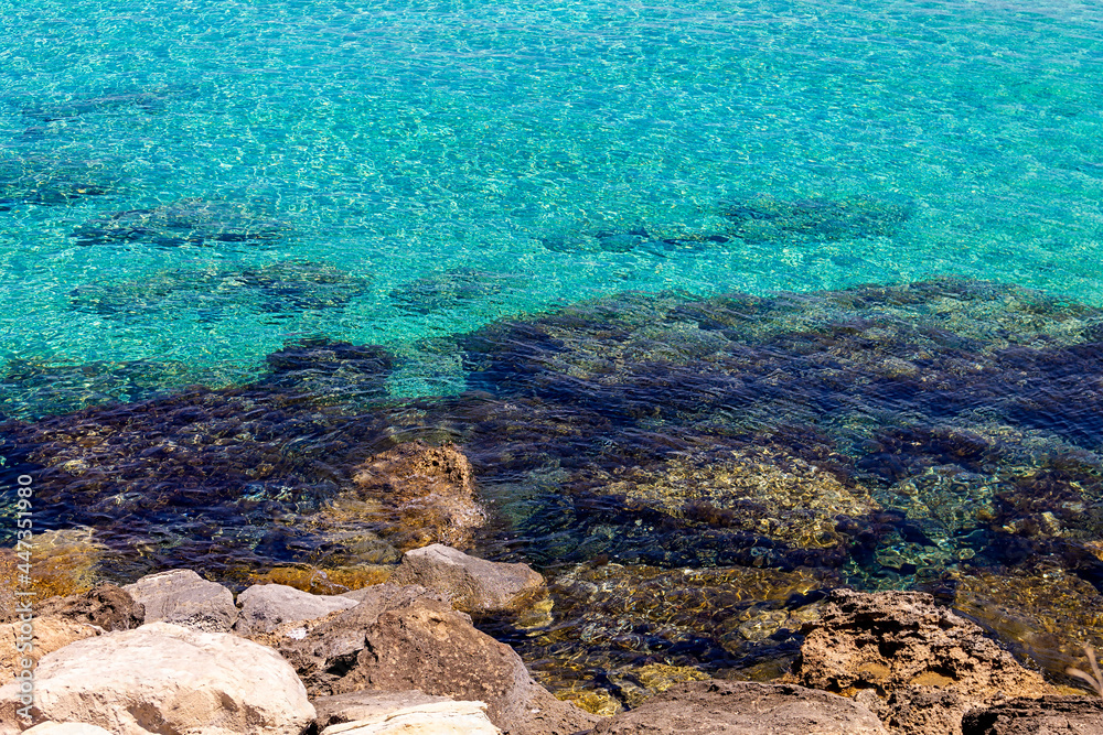 Azure clear water of the Mediterranean Sea. The rocky coast of the resort village of Protaras on the island of Cyprus. No people.