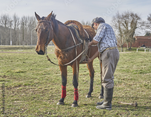 hombre preparando su caballo