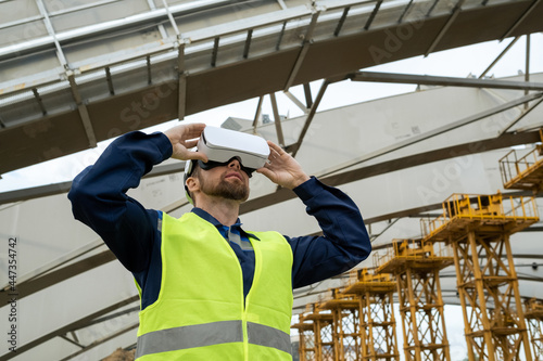 Young engineer using virtual reality glasses in his work he working on construction site