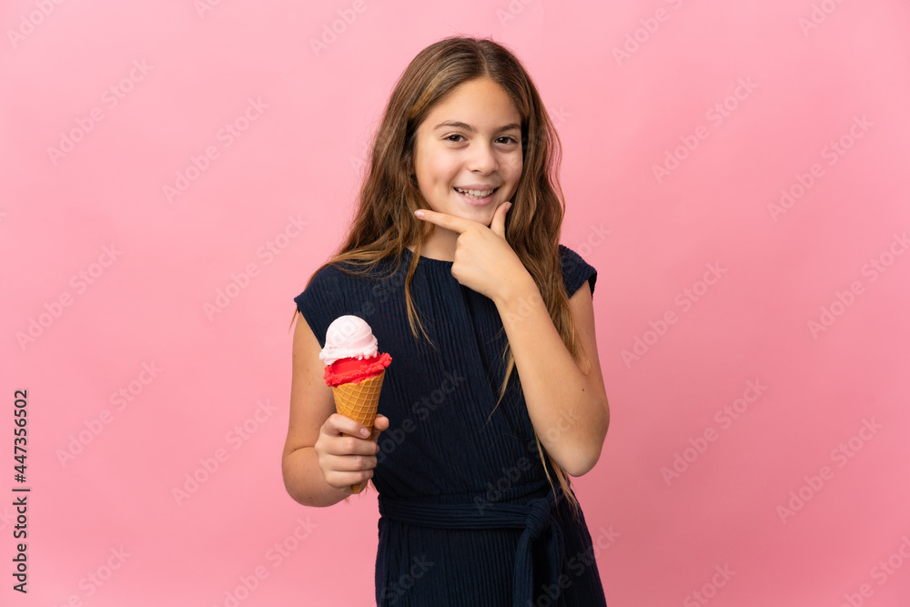 Child with a cornet ice cream over isolated pink background happy and smiling Child with a cornet ice cream over isolated pink background happy and smiling