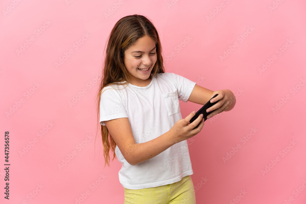 Child over isolated pink background playing with the mobile phone Child over isolated pink background playing with the mobile phone