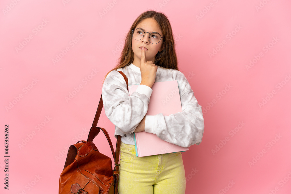 Student little girl over isolated pink background having doubts while looking up Student little girl over isolated pink background having doubts while looking up