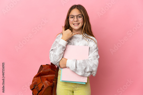 Student little girl over isolated pink background making phone gesture. Call me back sign photo