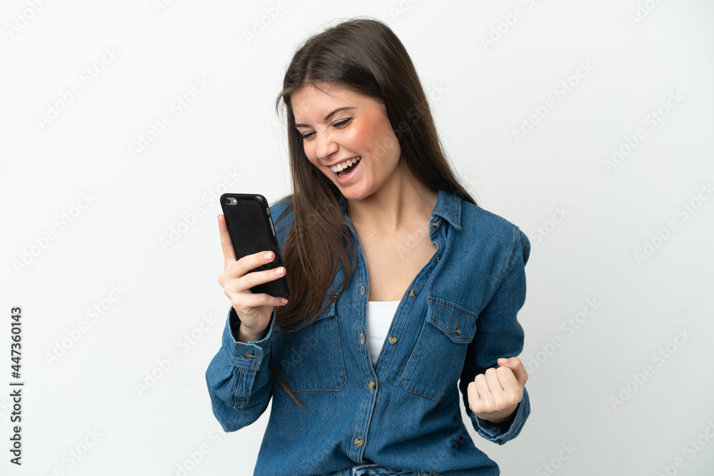 Young caucasian woman isolated on white background using mobile phone and doing victory gesture Young caucasian woman isolated on white background using mobile phone and doing victory gesture