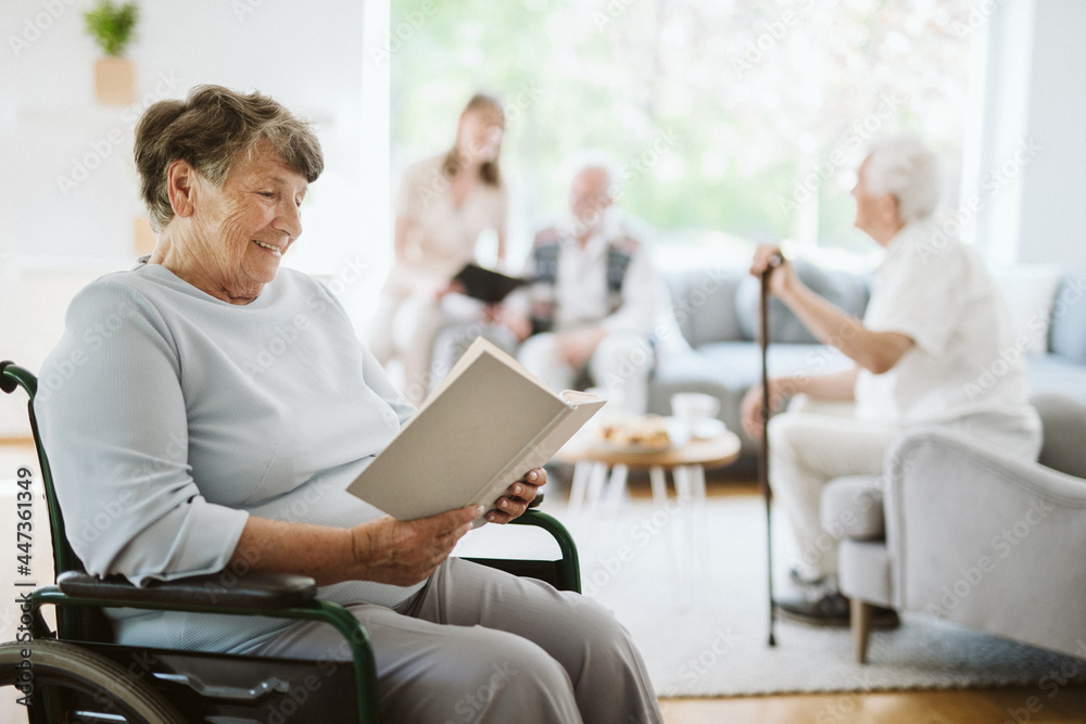 Happy disabled woman reading a book in the nursing home Happy disabled woman reading a book in the nursing home