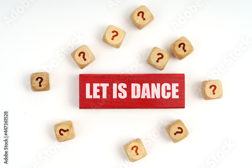 On the table are cubes with questions and a red plaque with the inscription - Let Is Dance