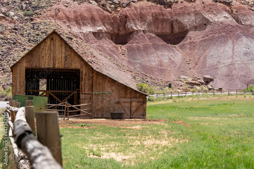 Historic old barn inside of Capitol Reef National Park, with fence in foreground photo