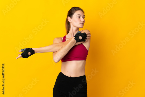 Young Ireland woman isolated on yellow background stretching arm
