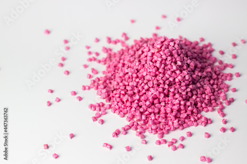 Pink granules of polypropylene or polyamide on a white background. Plastics and polymers industry. Copy space.