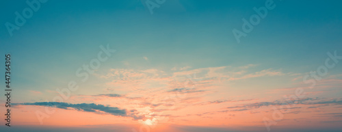 Panoramic picture of dawn sky with sun above the horizon surrounded by little cloudiness. Light Clouds at dawn. Orange Stripe of sky on blue horizon with rising sun, template for replacing sky.
