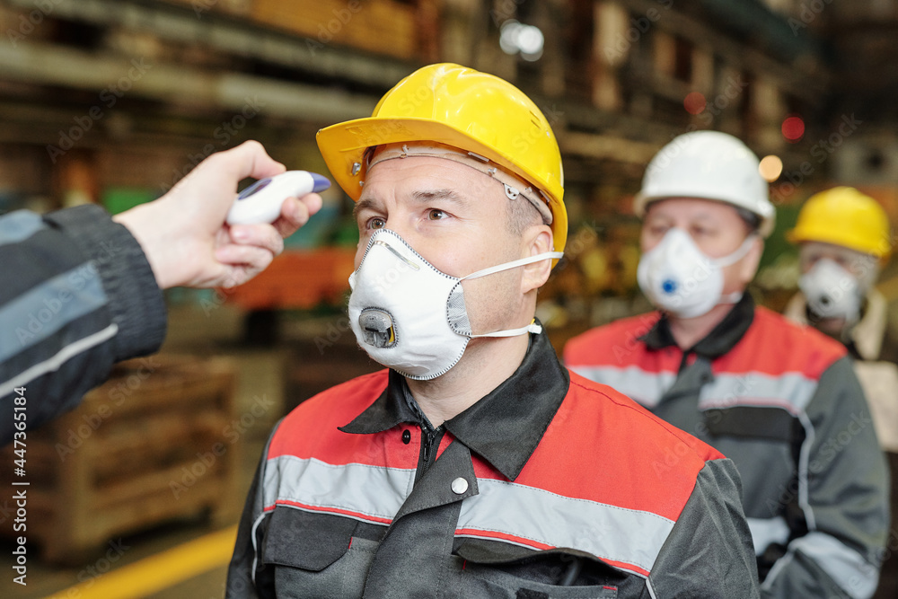 Checking temperature of factory workers Checking temperature of factory workers
