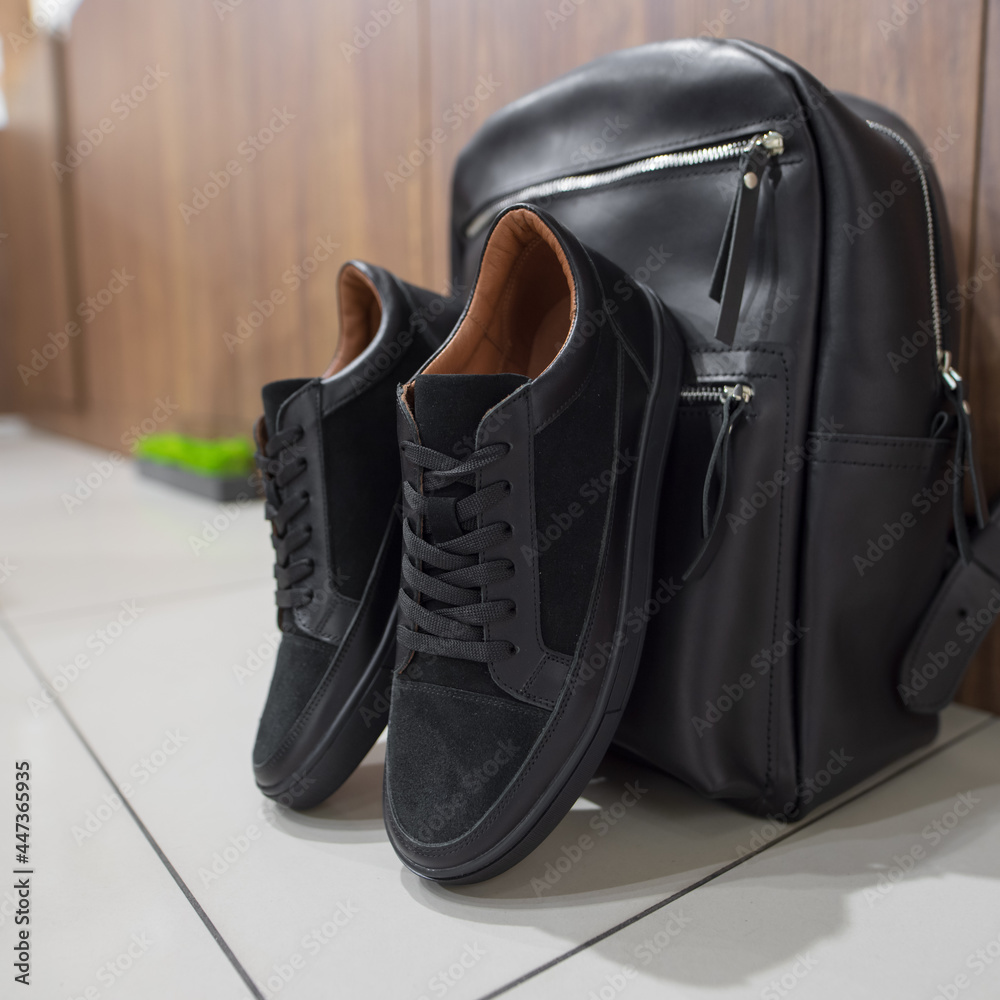 A new black sneakers near the bag A new black sneakers near the bag