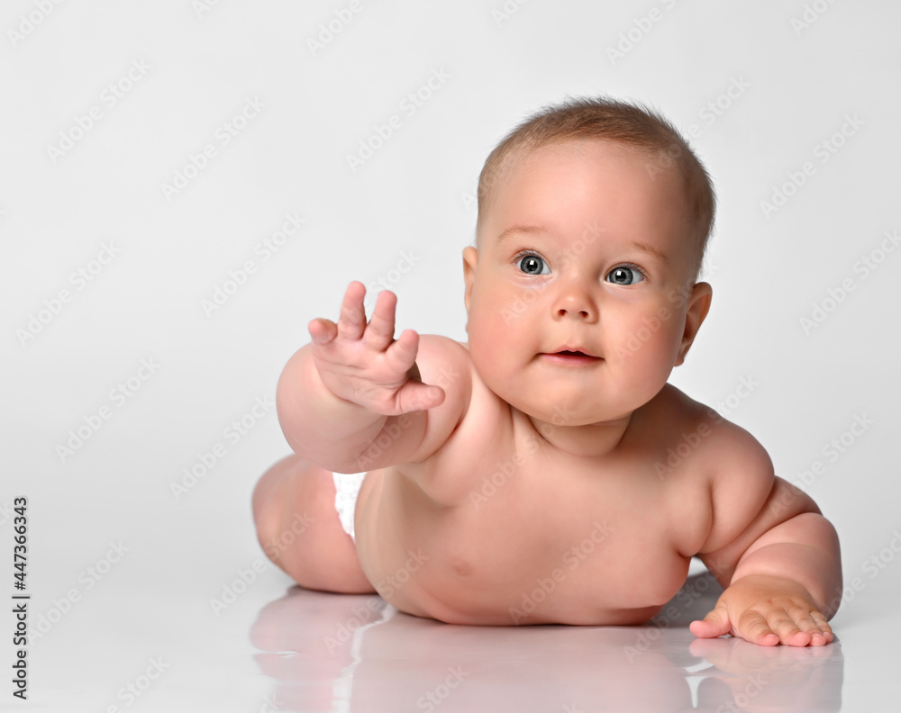 baby chubby in one diaper lies on the light floor and lifted the handle up. baby chubby in one diaper lies on the light floor and lifted the handle up.
