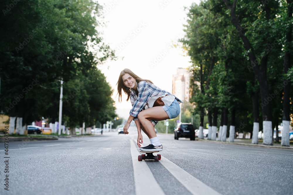 Euphoric happy woman riding on a skateboard on an empty city road in morning