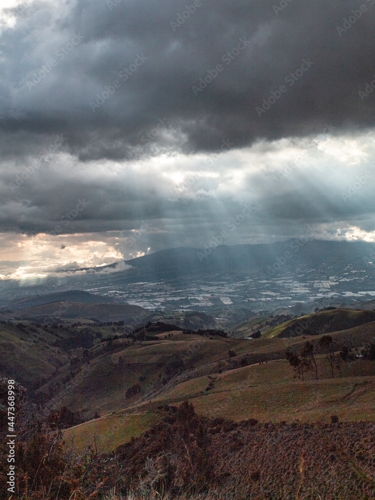 Valley landscape beams of light cloudy sunset at Cayambe
