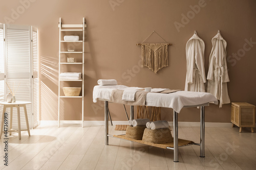 Stylish spa salon interior with massage table photo