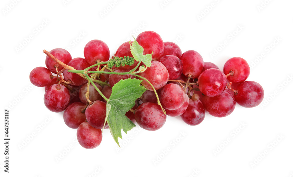 Cluster of ripe red grapes with green leaves on white background, top view
