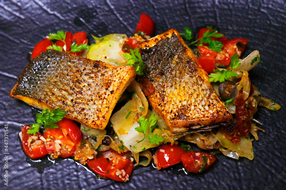 Foto Stock pan fried sea bass fillet with mediterranean style sauteed