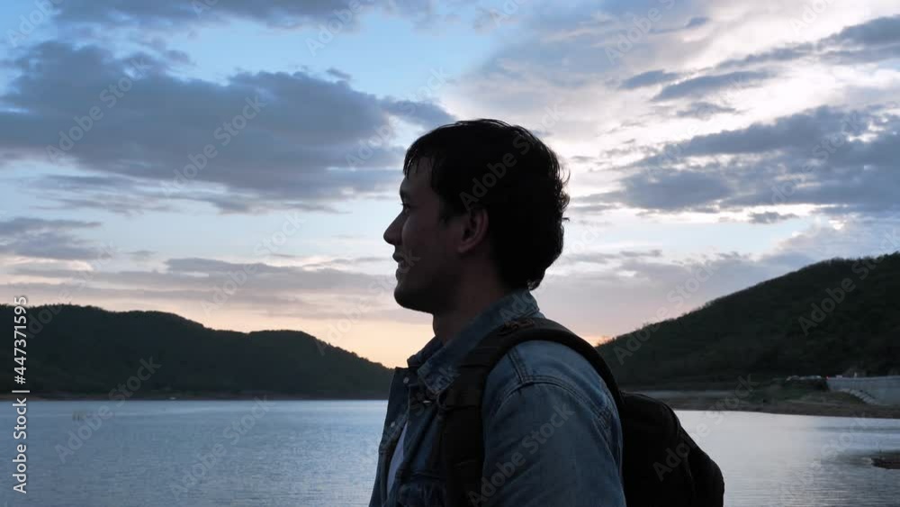 Young caucasian man traveler looking landscape and enjoying the beautiful nature in the evening Slow motion shot. Close up of Male with backpacks on the mountain. Travel, Hiking, and adventure Young caucasian man traveler looking landscape and enjoying the beautiful nature in the evening Slow motion shot. Close up of Male with backpacks on the mountain. Travel, Hiking, and adventure